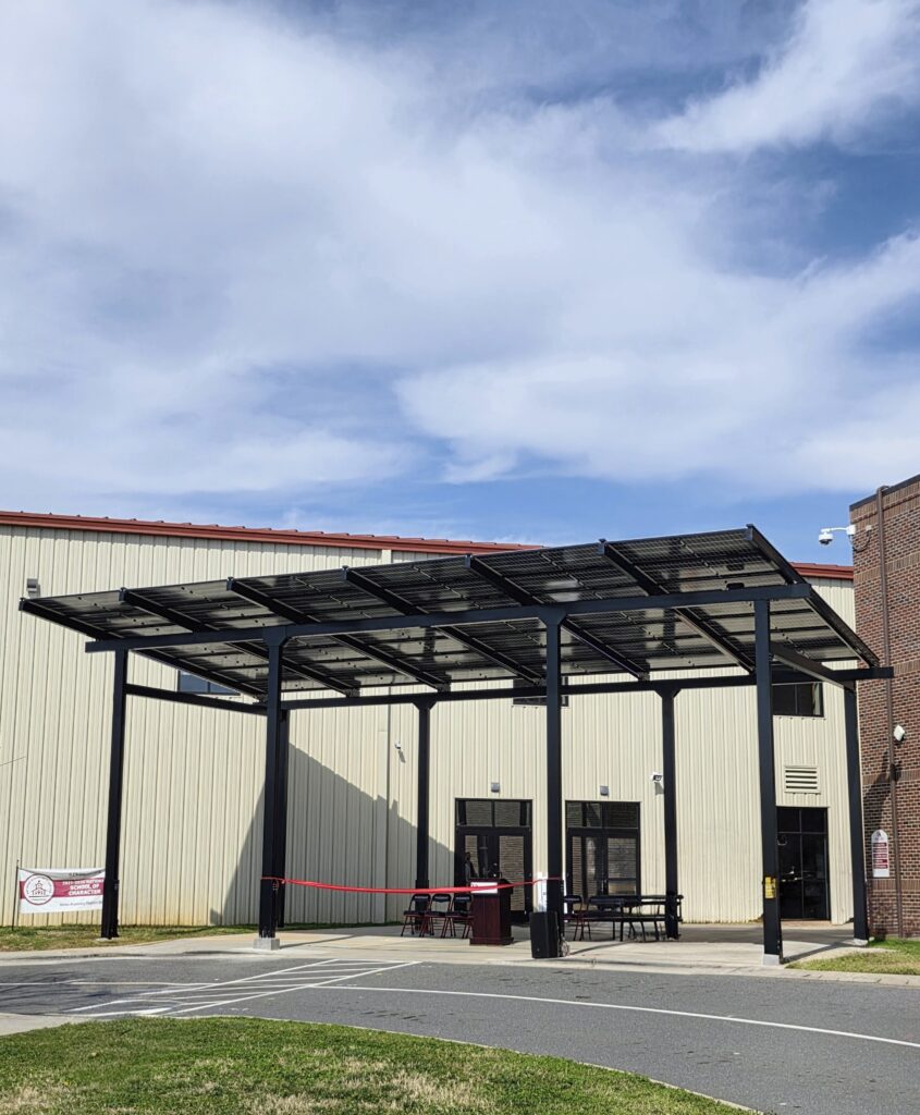 Solar canopy providing covered pickup and drop-off space at a school campus